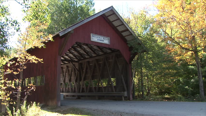 Montpelier, Vermont - CIRCA September 2007: A car drives through the Brookdale covered bridge over a river during the day in the forest