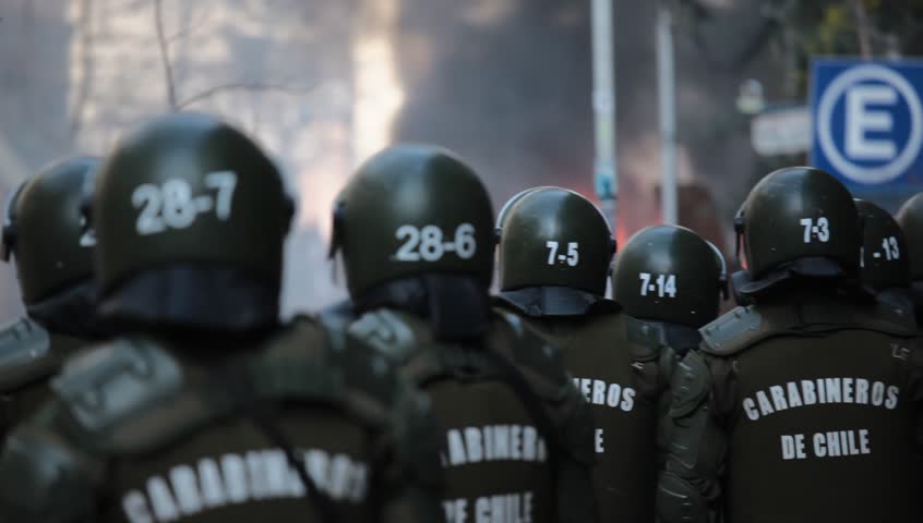 SANTIAGO, CHILE - AUGUST 9: Riot police disperse demonstrators who burned a car during a student strike on August 9, 2011 in Santiago, Chile.
