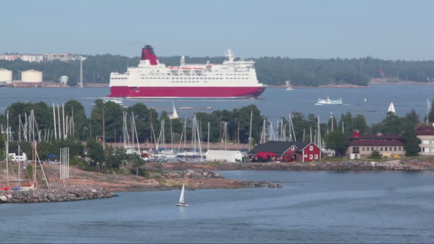 Huge liner among smaller vessels float near coastline beside Helsinki