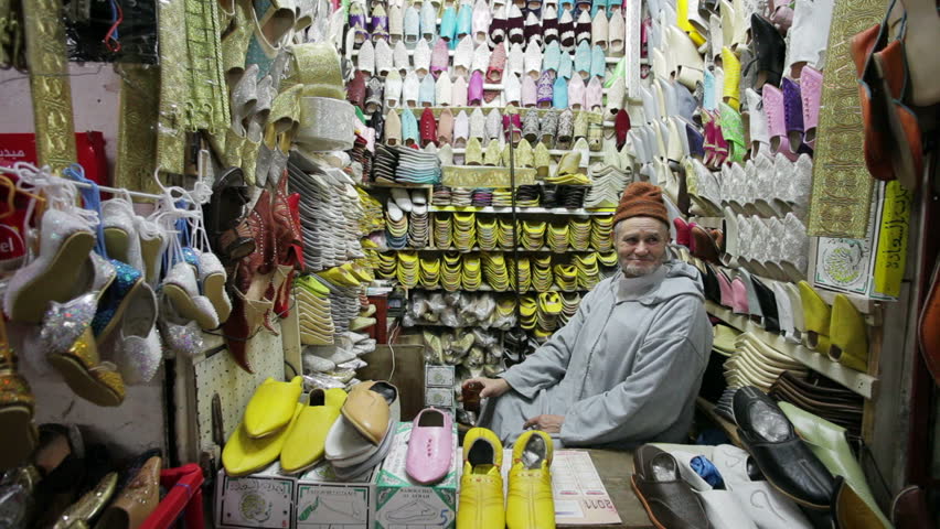 MARRAKESH, MOROCCO - CIRCA MAY 2011: Soft leather Moroccan slippers and a vendor in the Souk, Medina