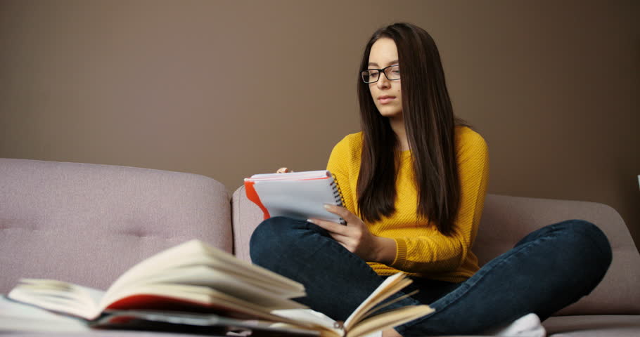 Concentrated Student Girl Studying On Floor And Writing In Notebook