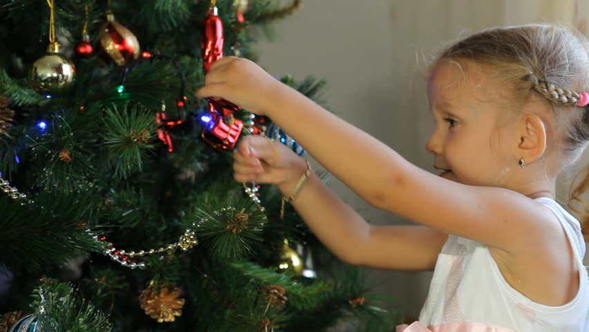 Child Decorating the Christmas Tree, Happy Little Girl Decorating the Christmas Tree