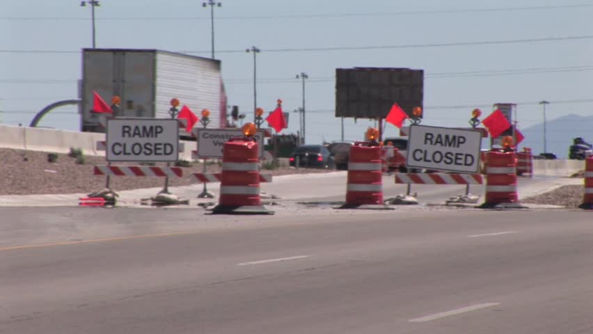 Ramp Closed Road Sign Block Entry To A Freeway; Flashing Detour Sign In The Background