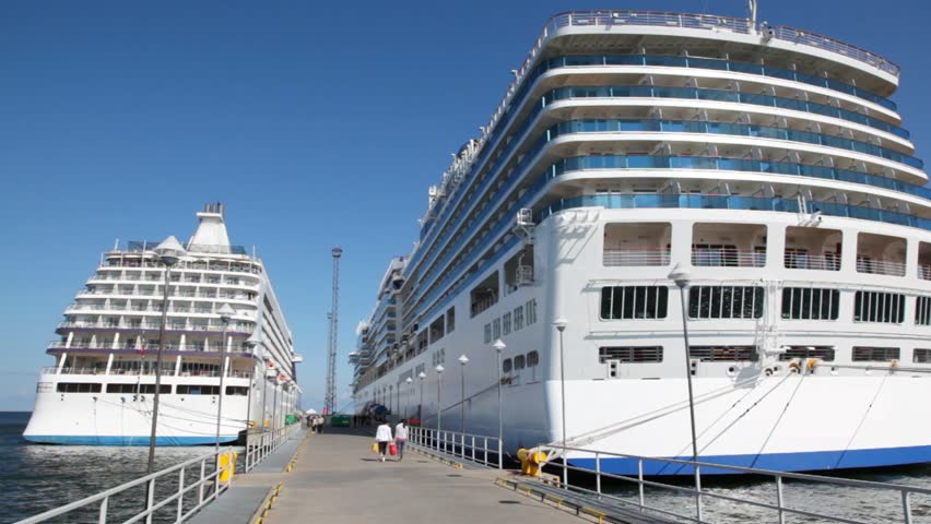 two big passenger liners stand in port on either side of mooring