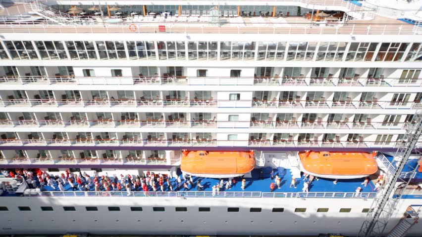 ranks of decks of huge passenger liner and people moving on lower deck during saving training