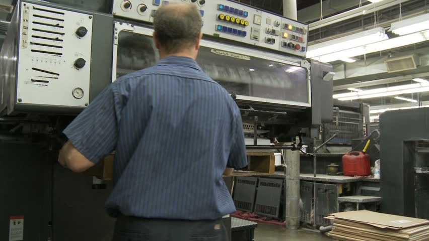 NEW ENGLAND, USA - CIRCA FEBRUARY 2009: Stack of paper being fed into commercial printing press 