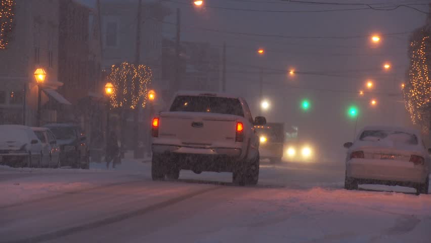 NEW ENGLAND - CIRCA NOVEMBER 2009: Small downtown scene during heavy snow storm with cars at night