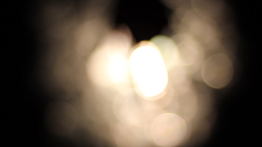 A hand in front of a light comes into focus as seen from below