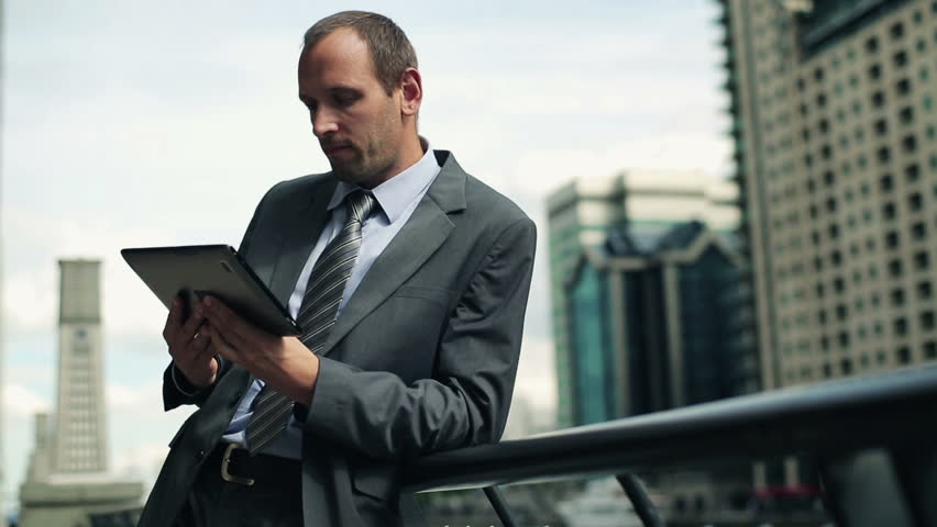 Businessman working on tablet computer in the city
