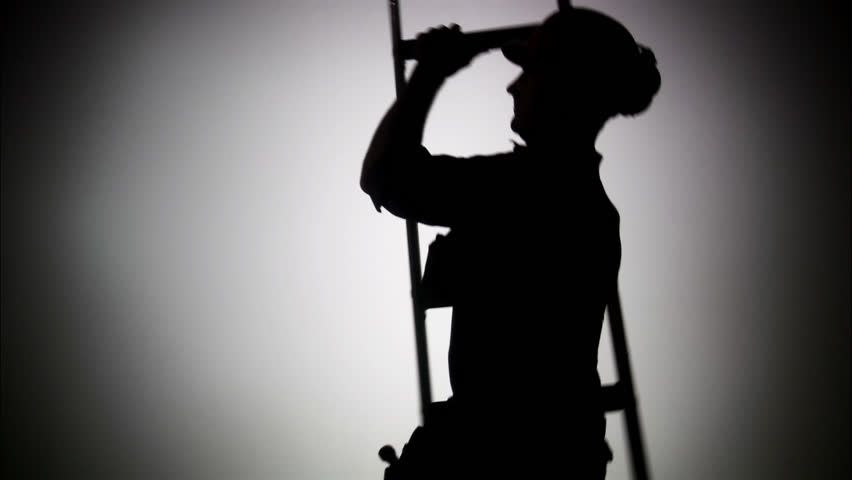 The silhouette of a construction worker with a ladder 