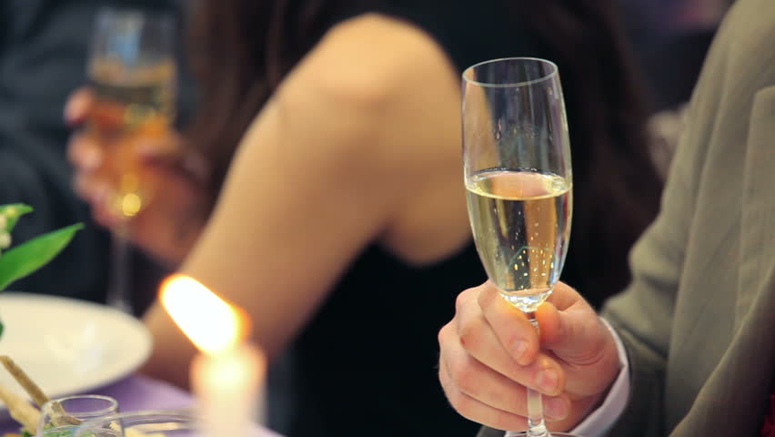 Raising glasses of champagne to a toast.
Raising glasses.