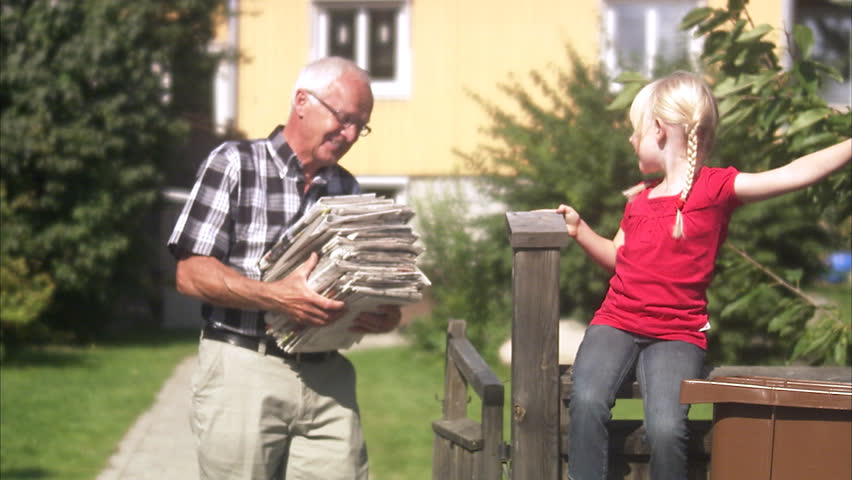 Girl and senior man recycling newspapers