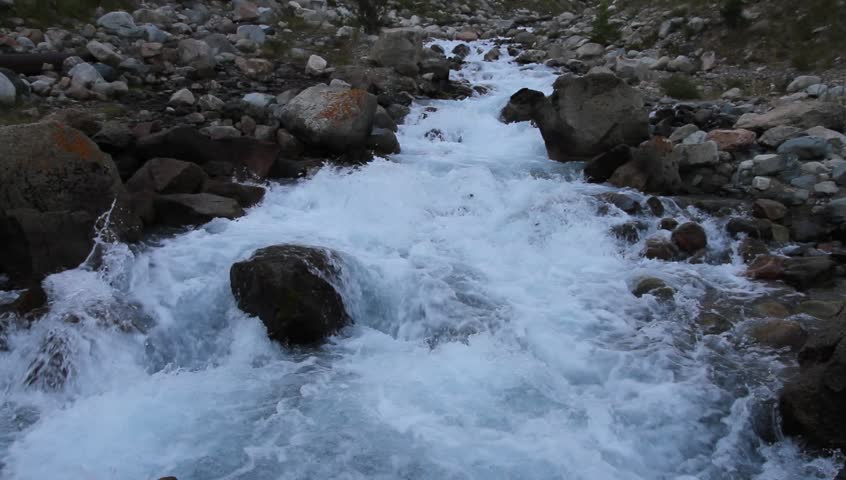 The mountain river among a heap of stones early in the morning