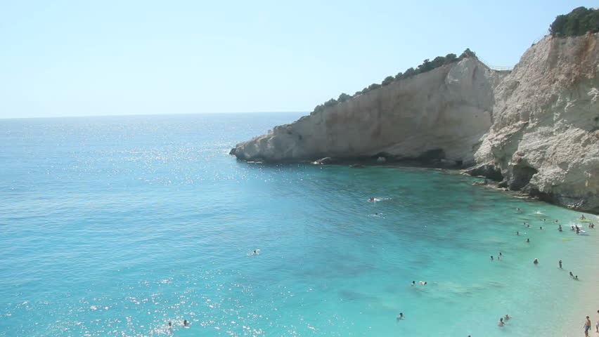 Blue Sea - Porto Katsiki, Lefkada - Crystal clear shallow blue water of Ionian sea, unrecognizeable people swimming in the distance, Greek Island of Lefkas, Lefkada, Greece