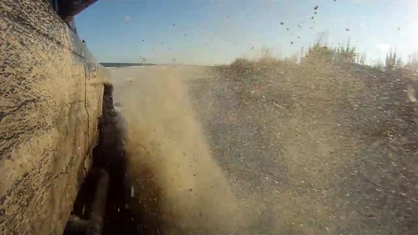 Off road driving in sand on a beach. Camera mounted at a low angle.