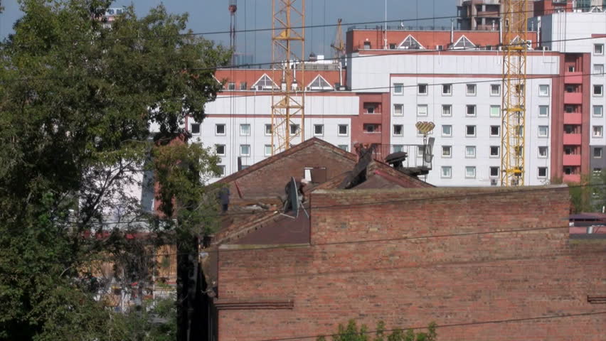 Time lapse workers dismantle the roof of an old house