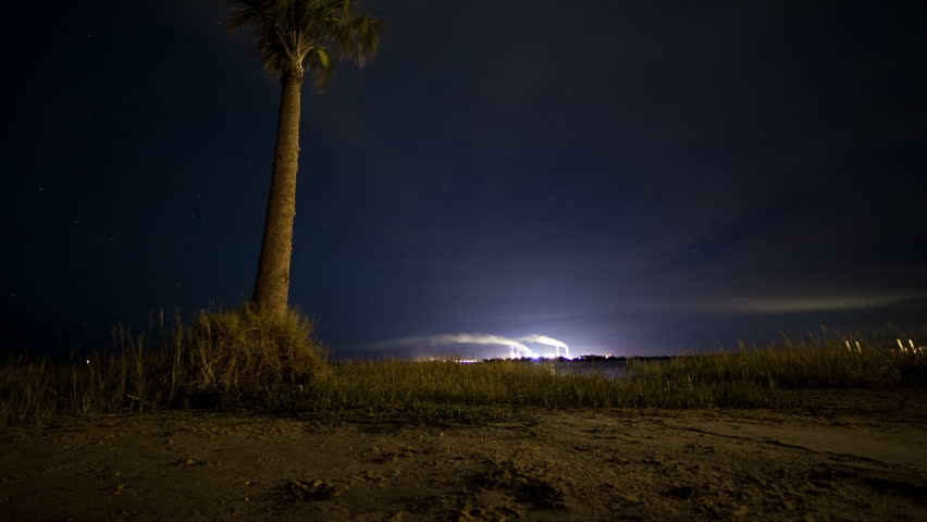 Power Plant at night motion time-lapse with palm tree and stars