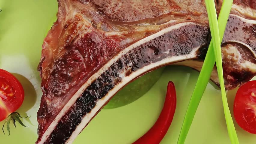 savory : grilled spare rib on green dish with thyme pepper and tomato isolated over white background