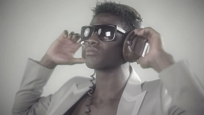 young african guy waving and dancing with a cool attitude with headphones and glasses