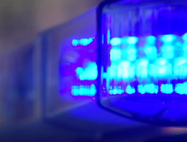 Red and blue police light bar on top of cruiser flashing at night DV NTSC video