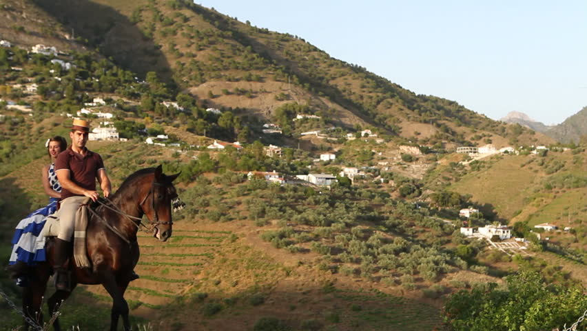Man and woman riding a horse in Andalusia, Spain
