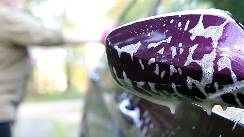 Back side mirror of vehicle in soap and washing car female