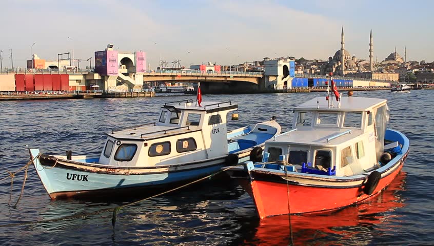 ISTANBUL - JUNE 4:  Lined up fisher boats in Goldenhorn looking to Bridge on June 4, 2012 in Istanbul. Galata Bridge is a bascule bridge which is a 490 m long and connects Old City to Karakoy Region.
