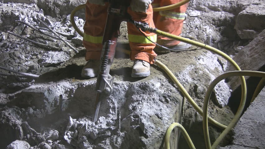 Jackhammers. Good audio. medium shot. Road crew working at night under bright lights.