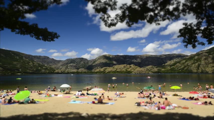Time lapse of people in the beach of Sanabria Lake Natural Park circa August 2012 in Sanabria, Spain. People blurred and unrecognizable.