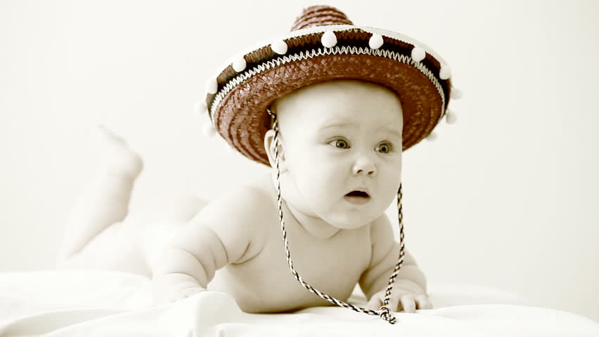 Baby in sombrero hat with maracas on the light background