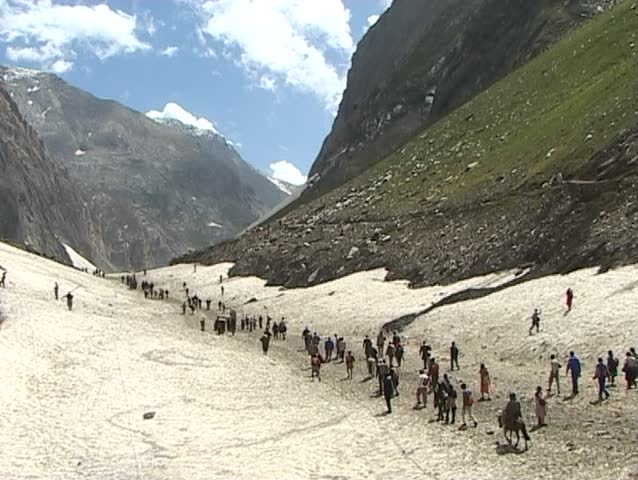 Pilgrimage to the holy Amarnath cave in the Himalayas. Hindu pilgrims crossing snow field