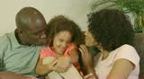 Portrait of African American family playing on couch