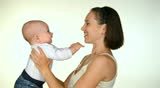 happy mother smiling and kissing her little child  in studio