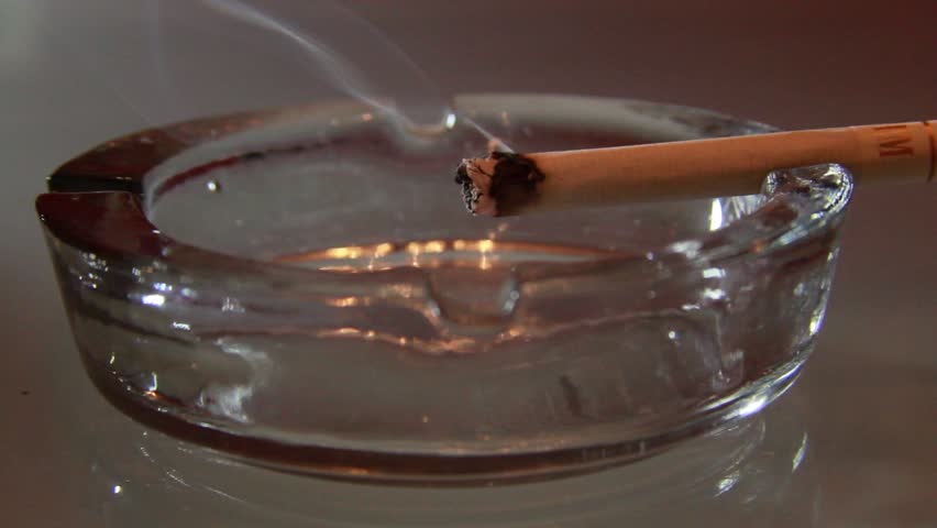 A burning cigarette in an ashtray