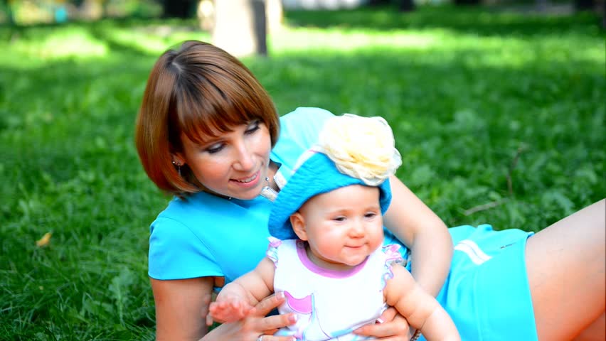 Happy Mother and her baby girl play outdoor
