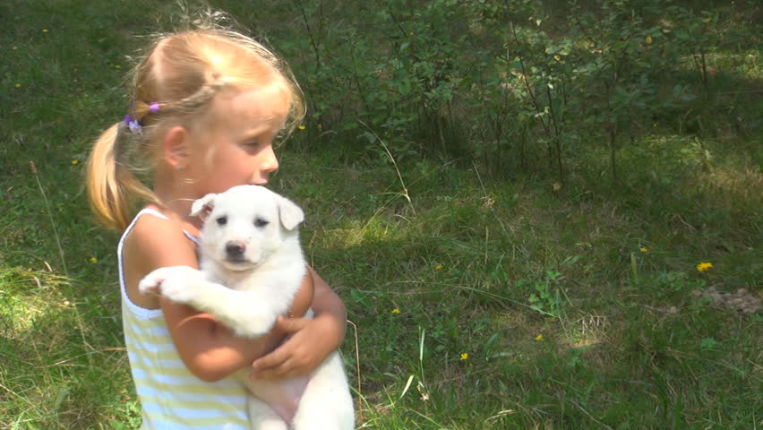 Child Nursing her Puppy, Little Girl Having Fun Playing with her Dog