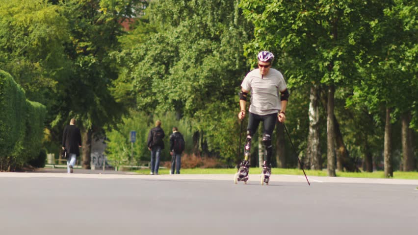 Disabled skater in city park. Nordic skates. Slow motion shot.