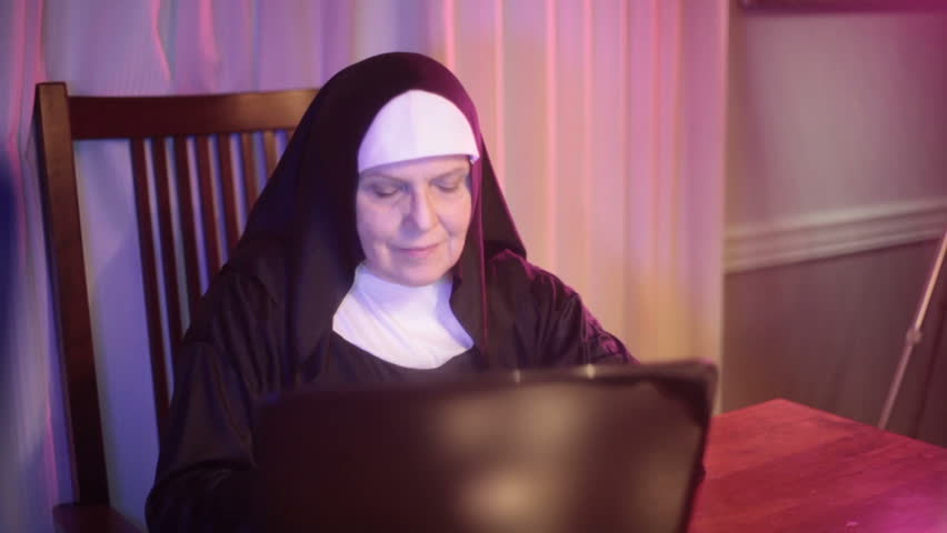 nun typing on the computer