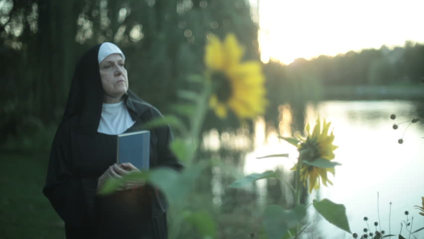 nun with a bible outside.
