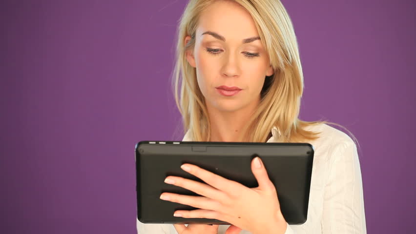 Happy blonde student working on a tablet