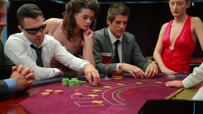 Man in sunglasses is happy with the cards he is dealt in casino
