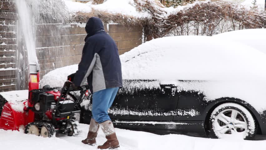 SOELDEN - FEB 16: Man cleans snow near house by snowplow, on Feb 15, 2012 in Soelden, Austria