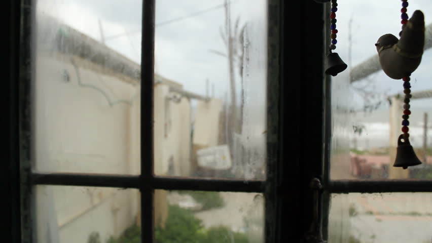 Staring through a window gazing at the sea in a stormy weather + slow elegant pan