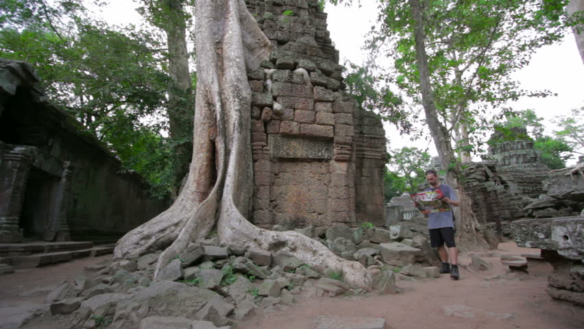 Visitor reading tourist information map in Ta Prohm temple, Angkor