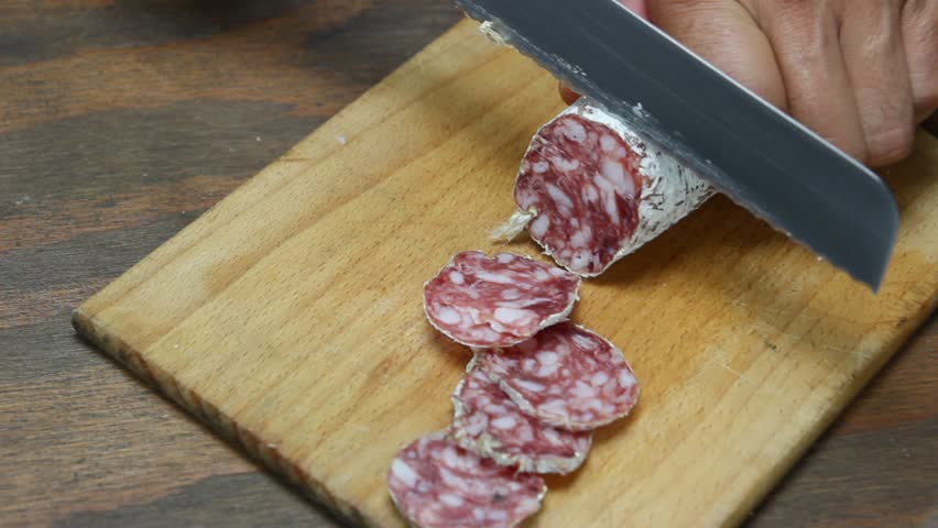  salami and  knife on wooden cutting board