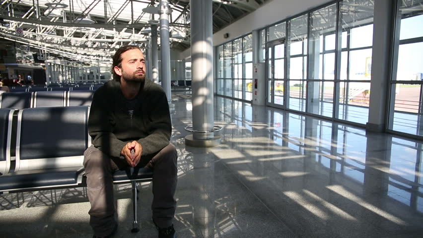 young man waiting his flight in airport lounge
