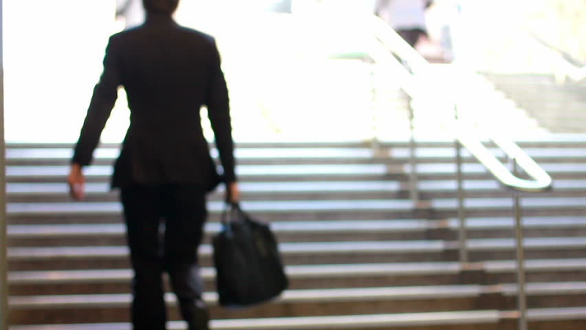 crowd of business commuters climb stairs