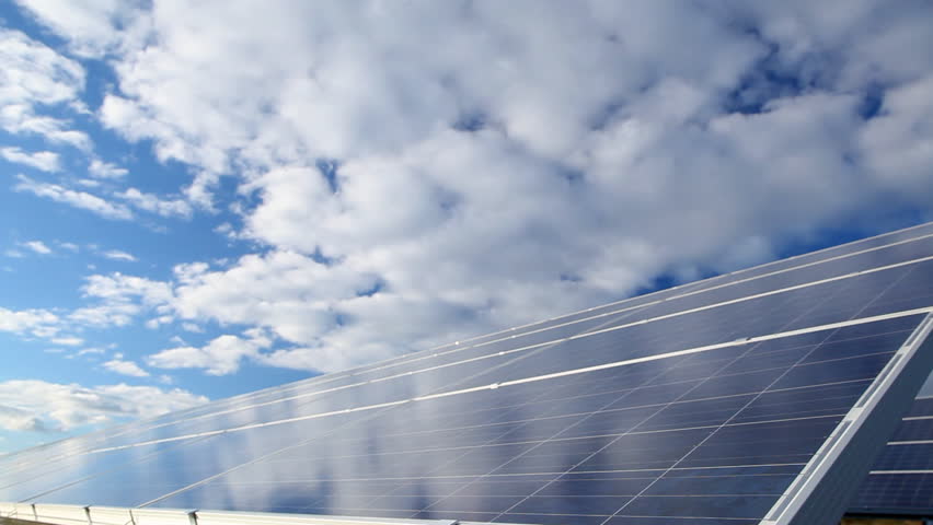 Time-lapse of moving clouds over solar photovoltaics panels field for renewable energy production