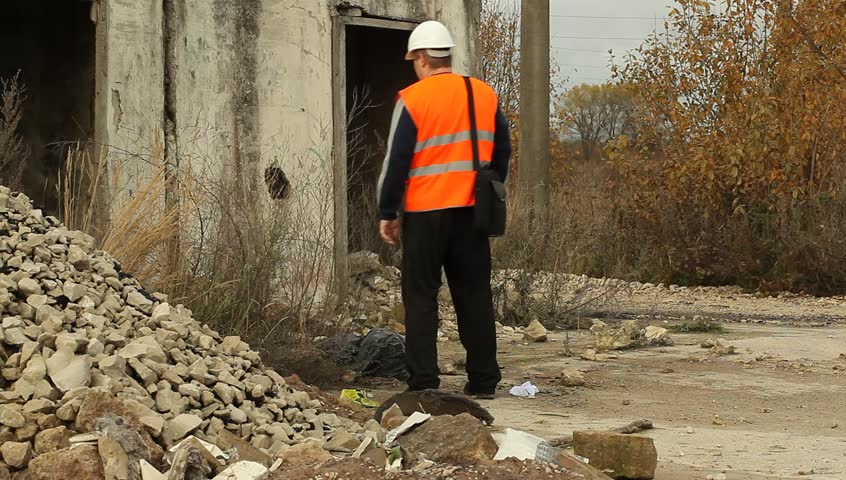 Engineer talking on the cell phone near the collapsed building