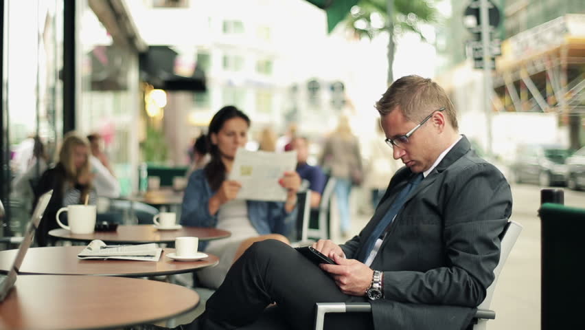 Businessman working on tablet computer in cafe, steadicam shot
